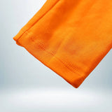 Zoom sur la couture des jambes du body bébé Goku – tissu orange vif et confortable